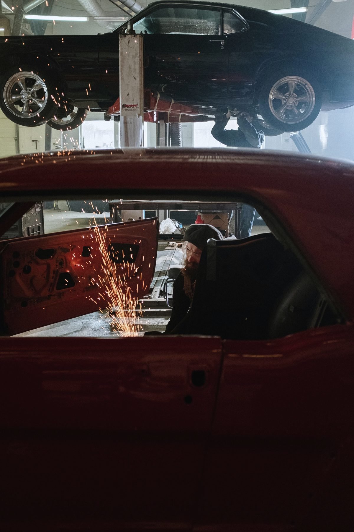 Sparks from welding seen through the door opening of a car body